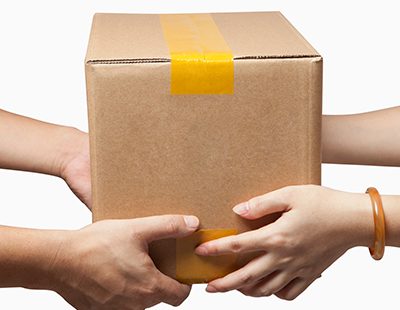 Someone handing a package to another to complete door to door services